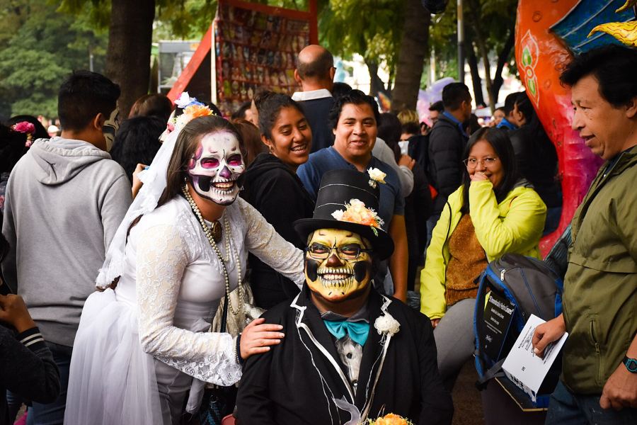 Catrinas and catrines in costume at a Day of the Dead parade